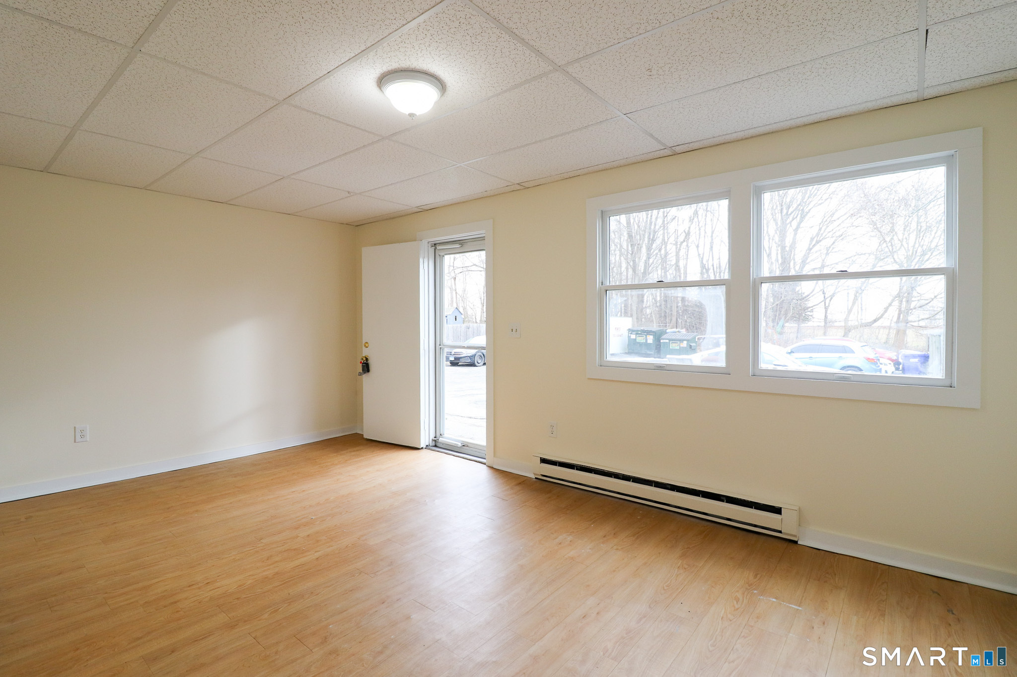 374 Main Street, Unit C Niantic, CT 06357 - Photo 4 of 31 an empty room with wooden floor and windows