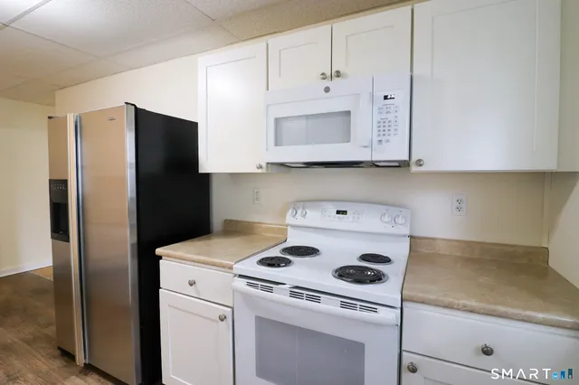 a kitchen with a refrigerator stove and cabinets