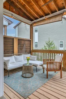 a view of a deck with couches table and chairs with wooden floor
