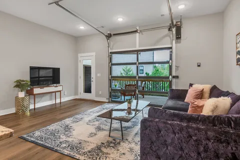 a living room with furniture a flat screen tv and a rug