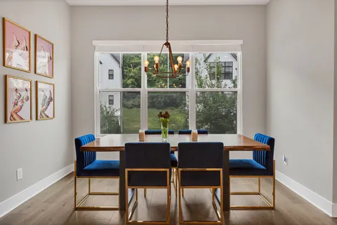 a dining room with furniture a chandelier and wooden floor