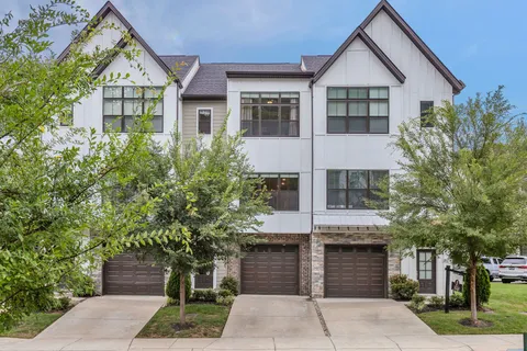 a front view of a house with a yard and trees