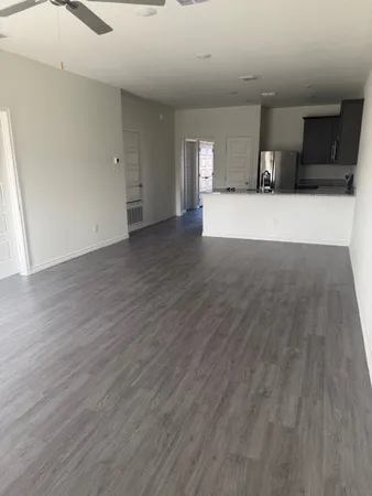 a view of a big room with wooden floor and windows