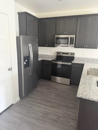 a kitchen with stainless steel appliances granite countertop a sink and a stove