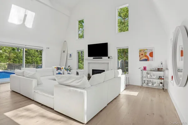 a living room with furniture a flat screen tv and a white bed