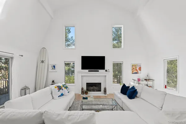 a living room with furniture a flat screen tv and a fireplace