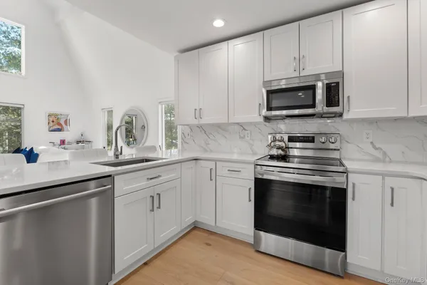 a kitchen with white cabinets stainless steel appliances and sink
