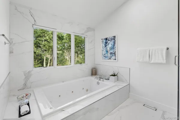 a bathroom with a bathtub and next to a window