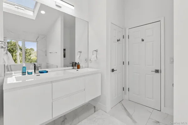 a bathroom with a double vanity sink mirror and a bathtub