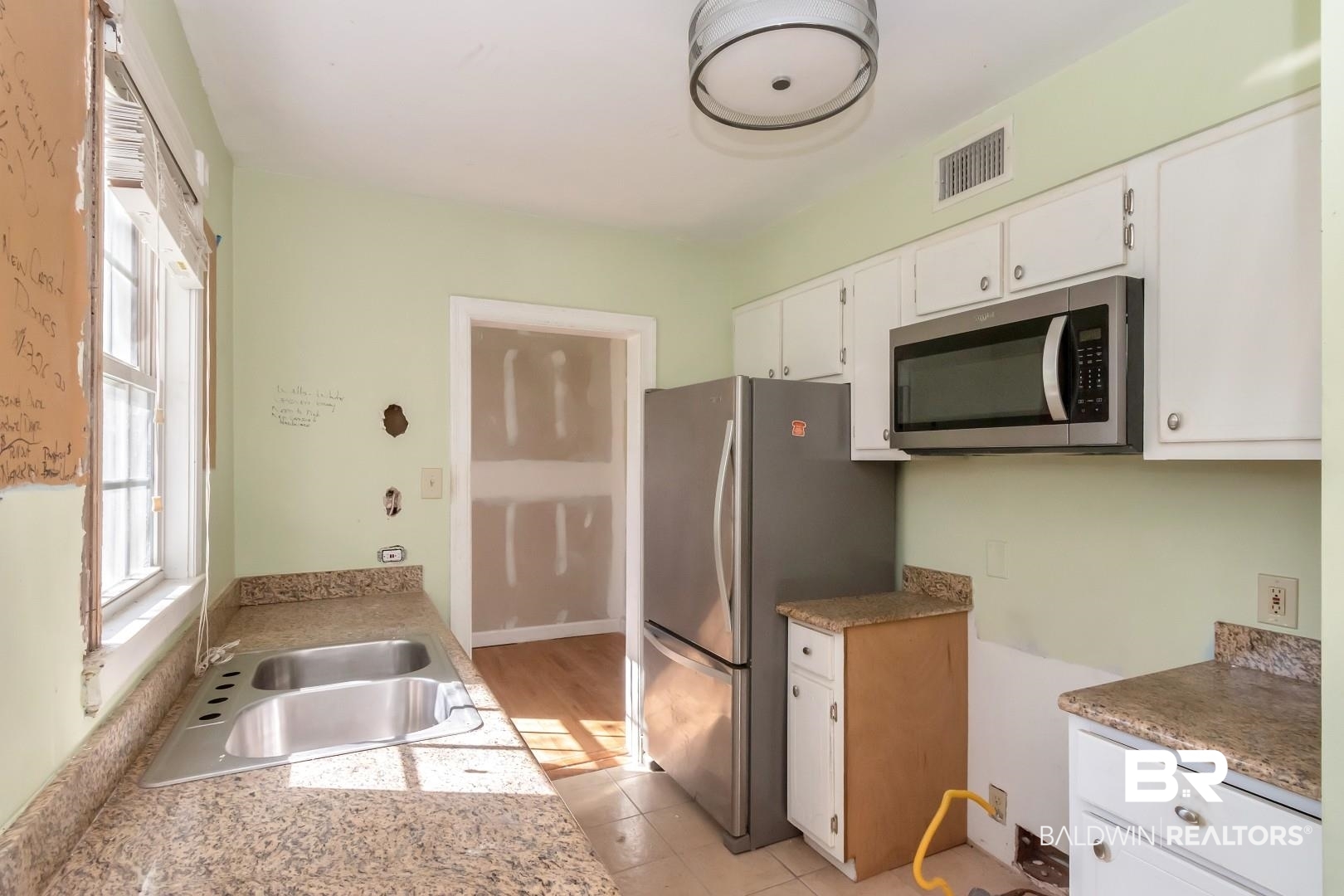 214 Upham Street, Unit 4A Mobile, AL 36607 - Photo 14 of 23 Kitchen featuring visible vents, a sink, stainless steel appliances, white cabinets, and light countertops