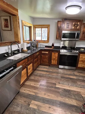 a large kitchen with stainless steel appliances granite countertop a stove a sink and a microwave