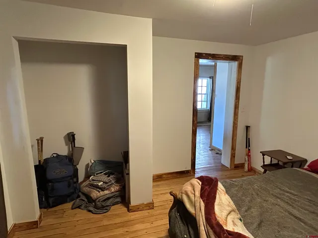 a bedroom with bed and wooden floor