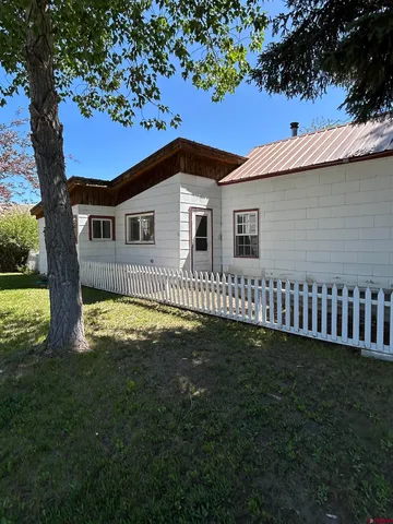 a backyard of a house with lots of green space and fountain