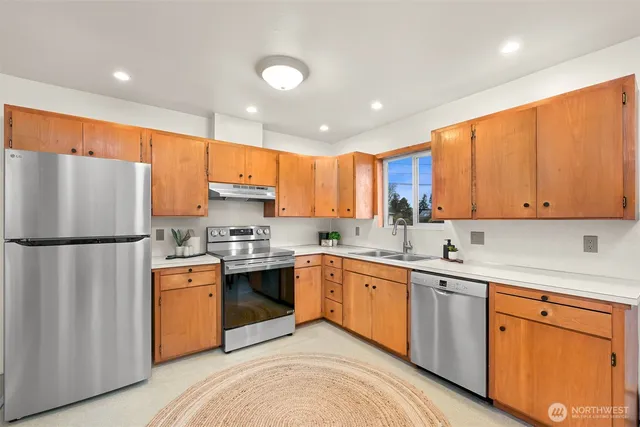a kitchen with a sink a refrigerator and cabinets