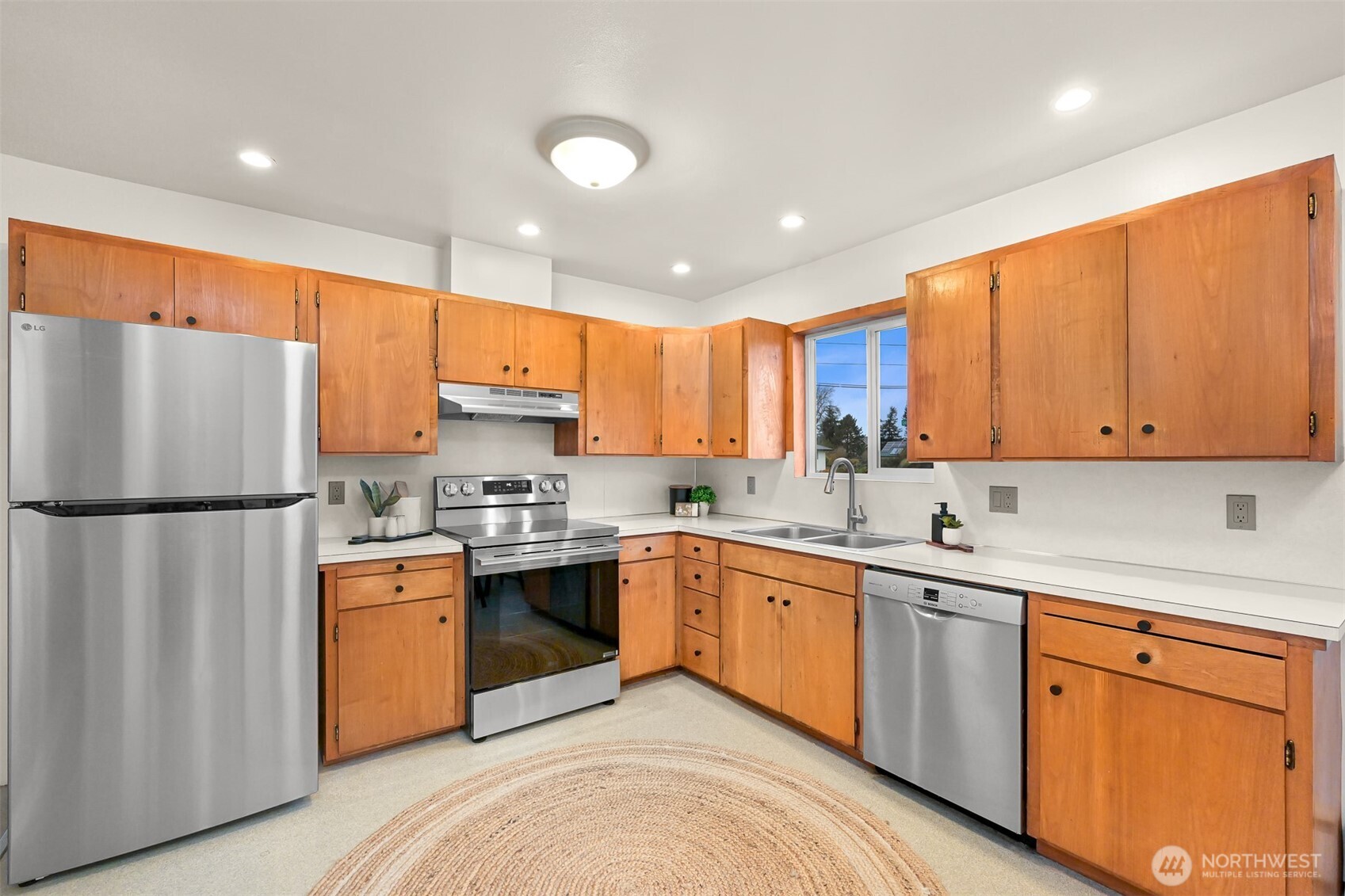 5811 Main Street Bow, WA 98232 - Photo 16 of 40 a kitchen with a sink a refrigerator and cabinets