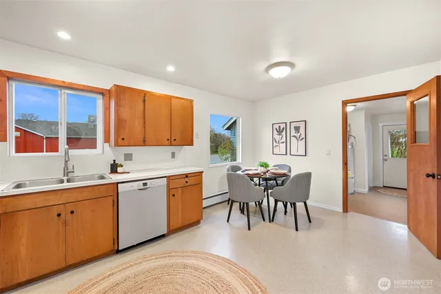 a kitchen with a sink table and chairs