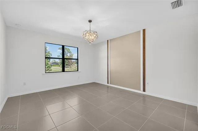 an empty room with windows and ceiling fan