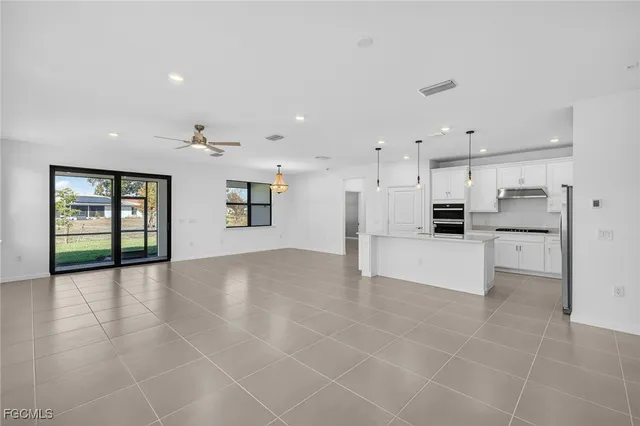 a view of kitchen with stainless steel appliances kitchen island cabinets and window
