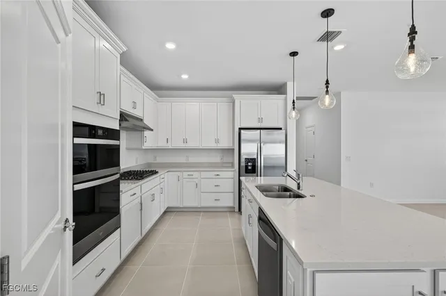 a kitchen with stainless steel appliances a stove a sink and a refrigerator