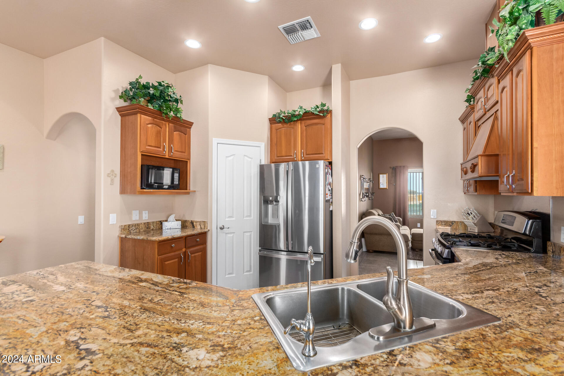 6786 Gelding Lane Coolidge, AZ 85128 - Photo 17 of 39 a kitchen with stainless steel appliances granite countertop a sink and a refrigerator