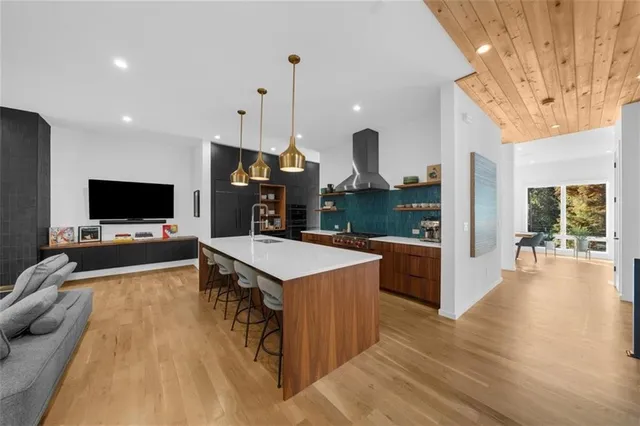 a living room with furniture kitchen view and a flat screen tv