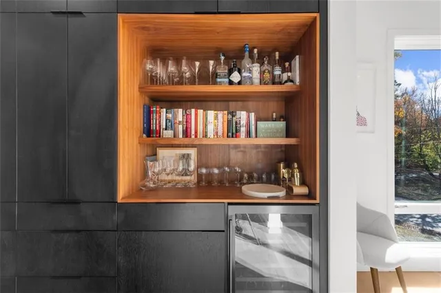 a view of a porch with wooden floor and bench next to a yard