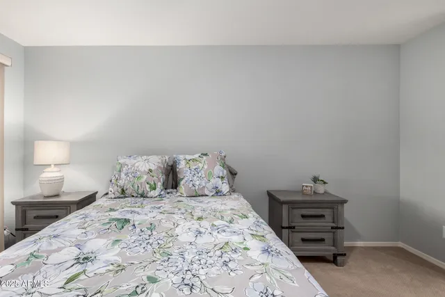 a bedroom with a bed and a lamp on the dresser