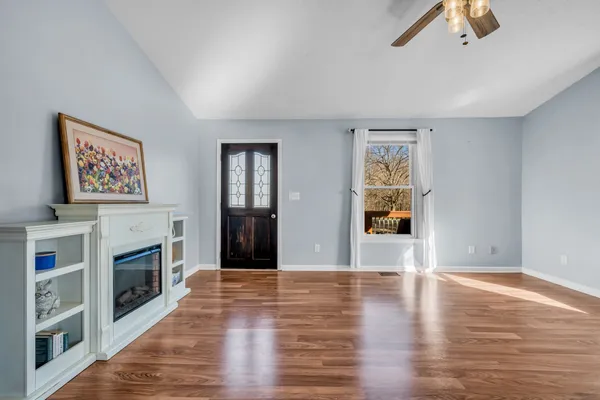 a view of a livingroom with wooden floor and a fireplace