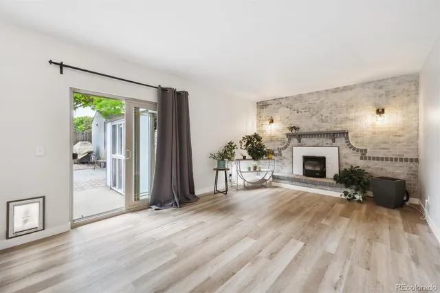 wooden floor fireplace and windows in an empty room