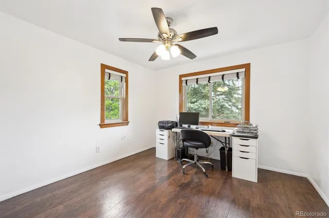 a view of a workspace with wooden floor and a window