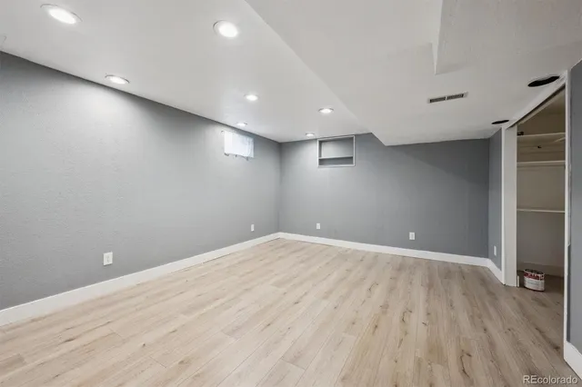 an empty room with wooden floor and entrance