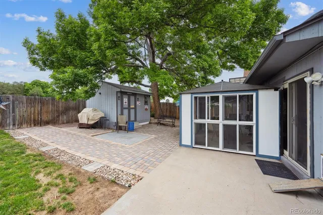 a view of a house with a yard and large tree