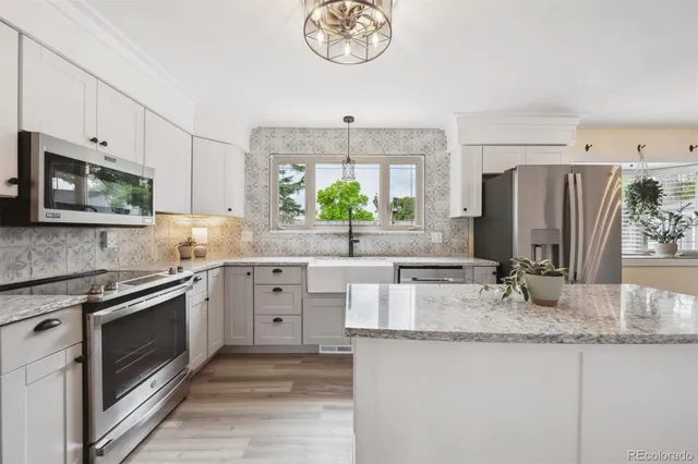 a kitchen with granite countertop a sink stainless steel appliances and a counter top space