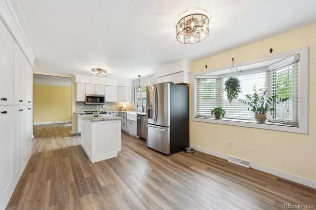 a kitchen with a refrigerator wooden floor and window