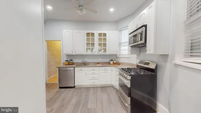a kitchen with stainless steel appliances granite countertop a stove a sink and a microwave