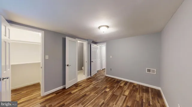a view of a room with wooden floor and a window