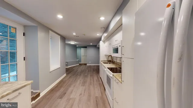 a view of a kitchen with a sink and refrigerator