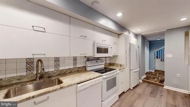 a kitchen that has a sink cabinets counter space and appliances