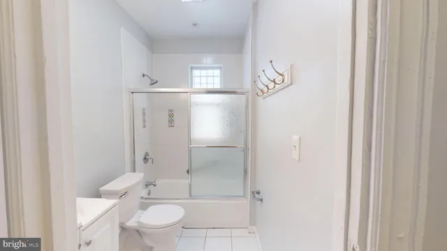 a bathroom with a granite countertop sink a toilet and shower