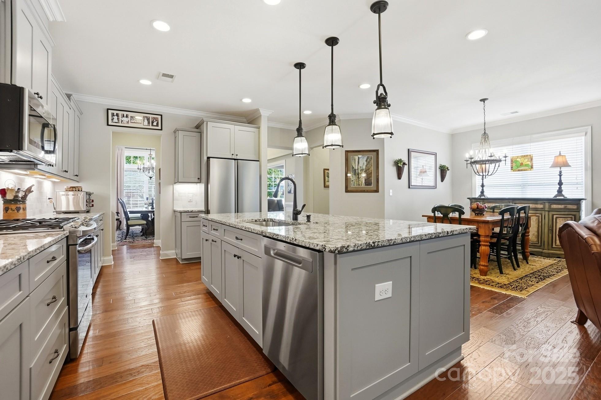 4069 Henshaw Road Waxhaw, NC 28173 - Photo 15 of 48 a kitchen with stainless steel appliances granite countertop a sink a stove and a wooden floors