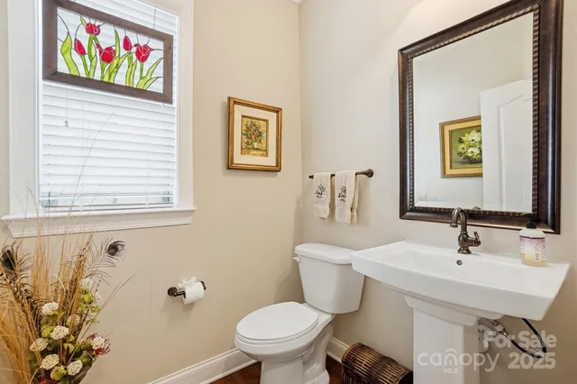 a bathroom with a toilet a sink and mirror