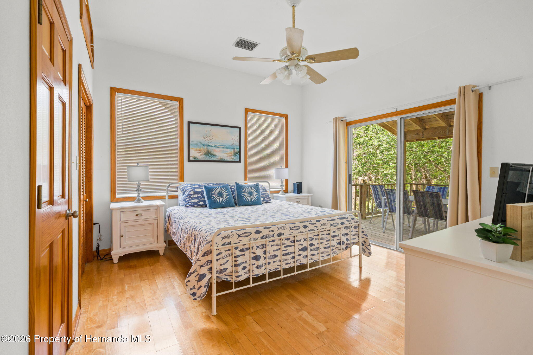1566 Indian Bay Road Spring Hill, FL 34607 - Photo 30 of 56 a bedroom with a bed and large windows