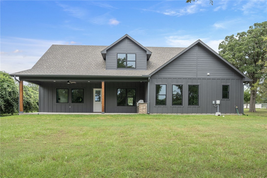 13291 Hopes Creek Road College Station, TX 77845 - Photo 30 of 45 Rear view of house featuring board and batten siding, roof with shingles, a lawn, and a porch