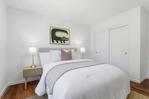 a bedroom with a bed and a painting on the wall