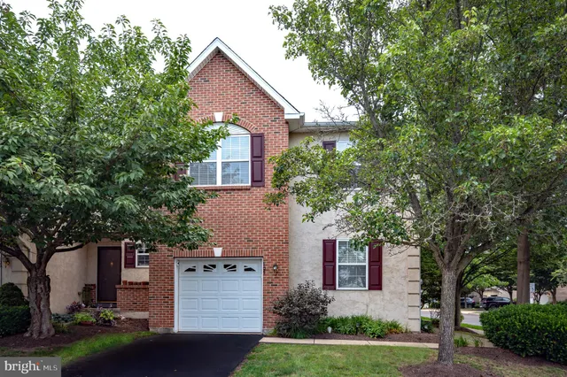 front view of a house with a yard and an trees