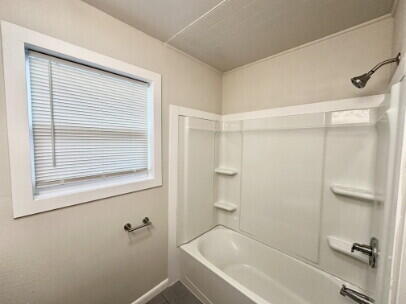 4214 37th Street Lubbock, TX 79413 - Photo 9 of 14 a bathroom with a bathtub and a shower