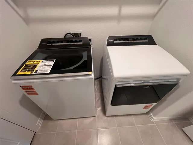 a view of a hallway with wooden floor and a refrigerator