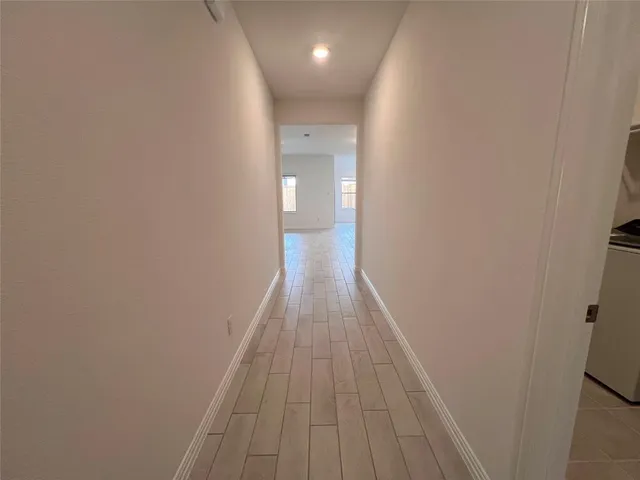 a view of hallway with wooden floor
