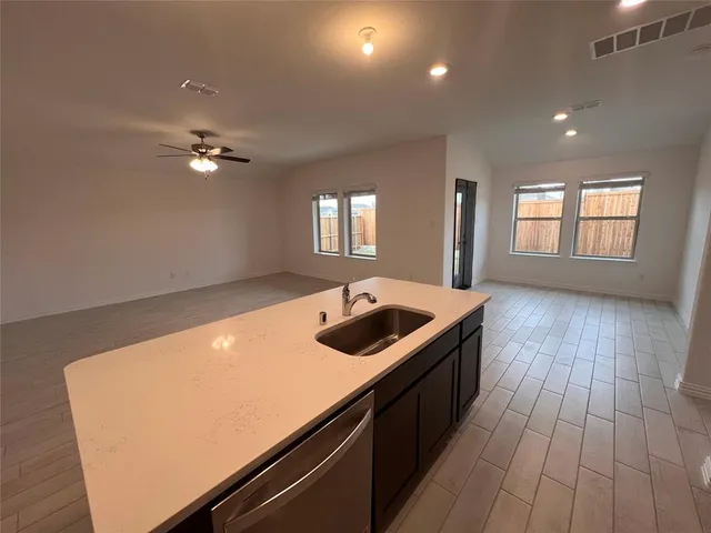 an open kitchen with a sink and dish washer