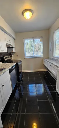 a kitchen with granite countertop a stove a sink and a microwave